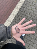 Person wearing Bars and Roses temporary pill tattoo on hand - streetwear style - Offnoir